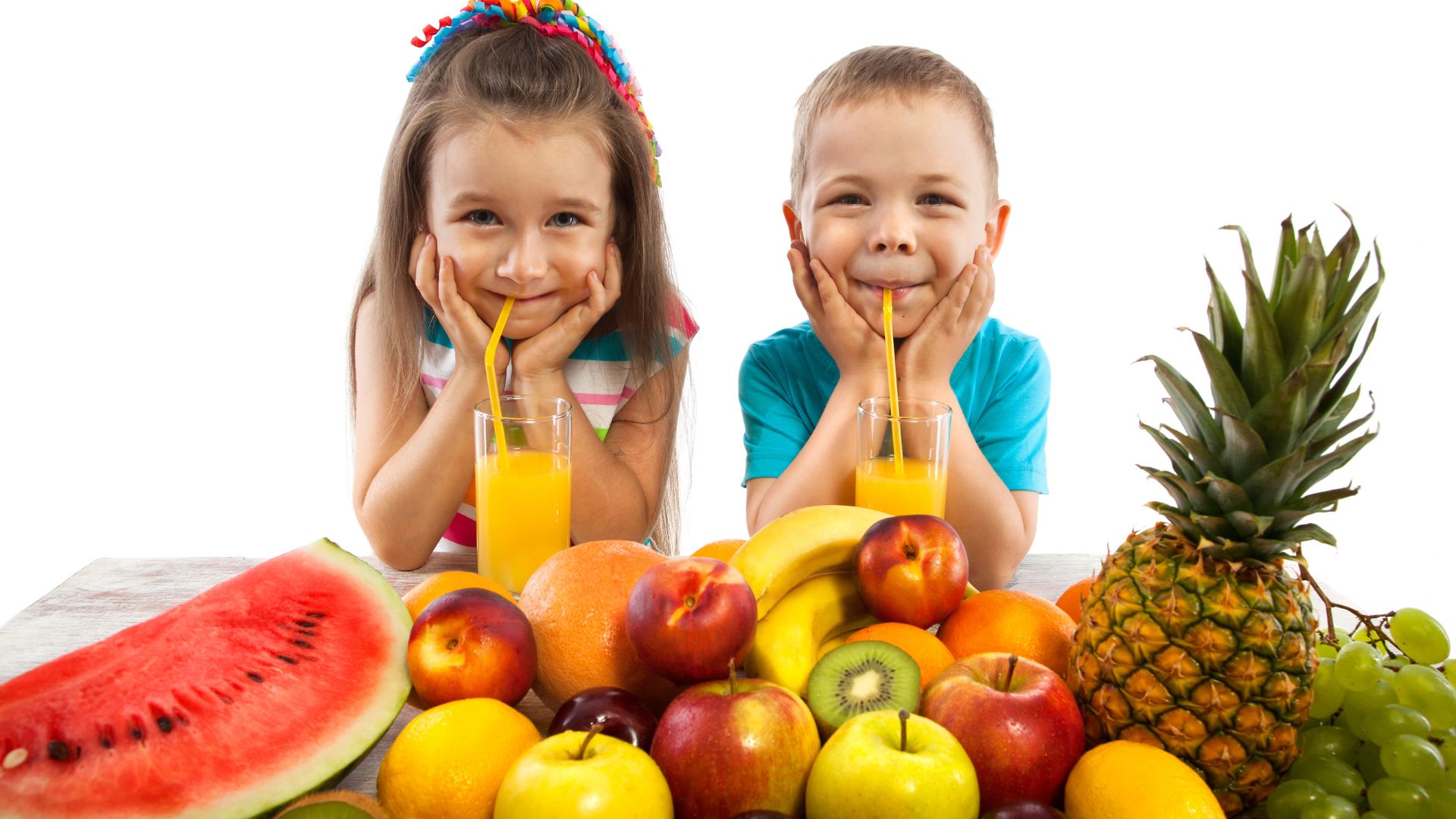 Chłopiec i dziewczynka przyjmują naturalne witaminy dla dzieci w sokach z owoców.