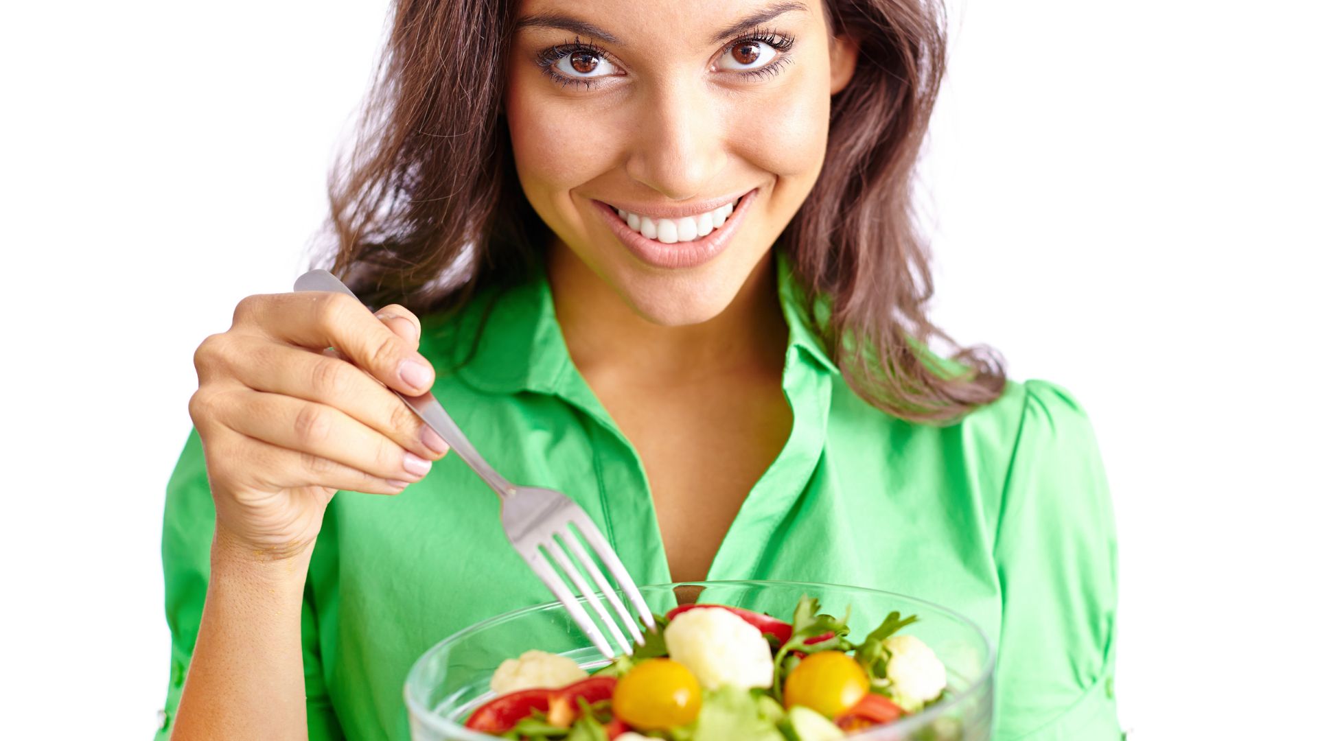 Witaminy dla wegetarian, takich jak kobieta na zdjęciu z zieloną sałatką, trudno otrzymać z naturalnych produktów.