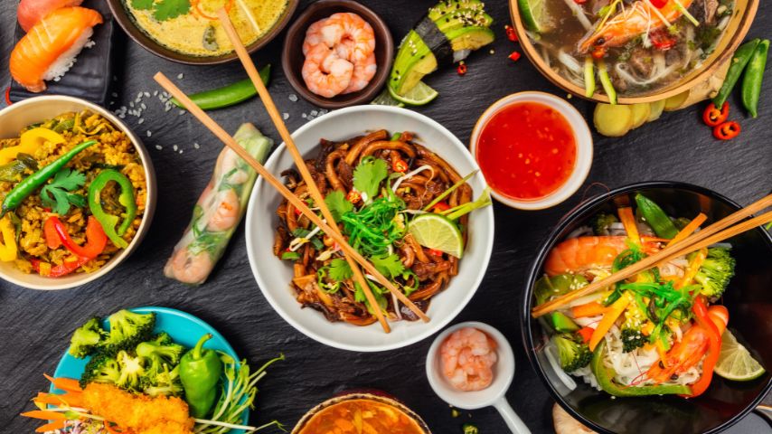 Azjatyckie jedzenie podane na talerzach i w półmiskach.