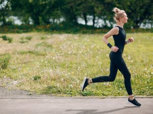 Ile powinno się biegać na początku? Na zdjęciu kobieta biega na świeżym powietrzu.